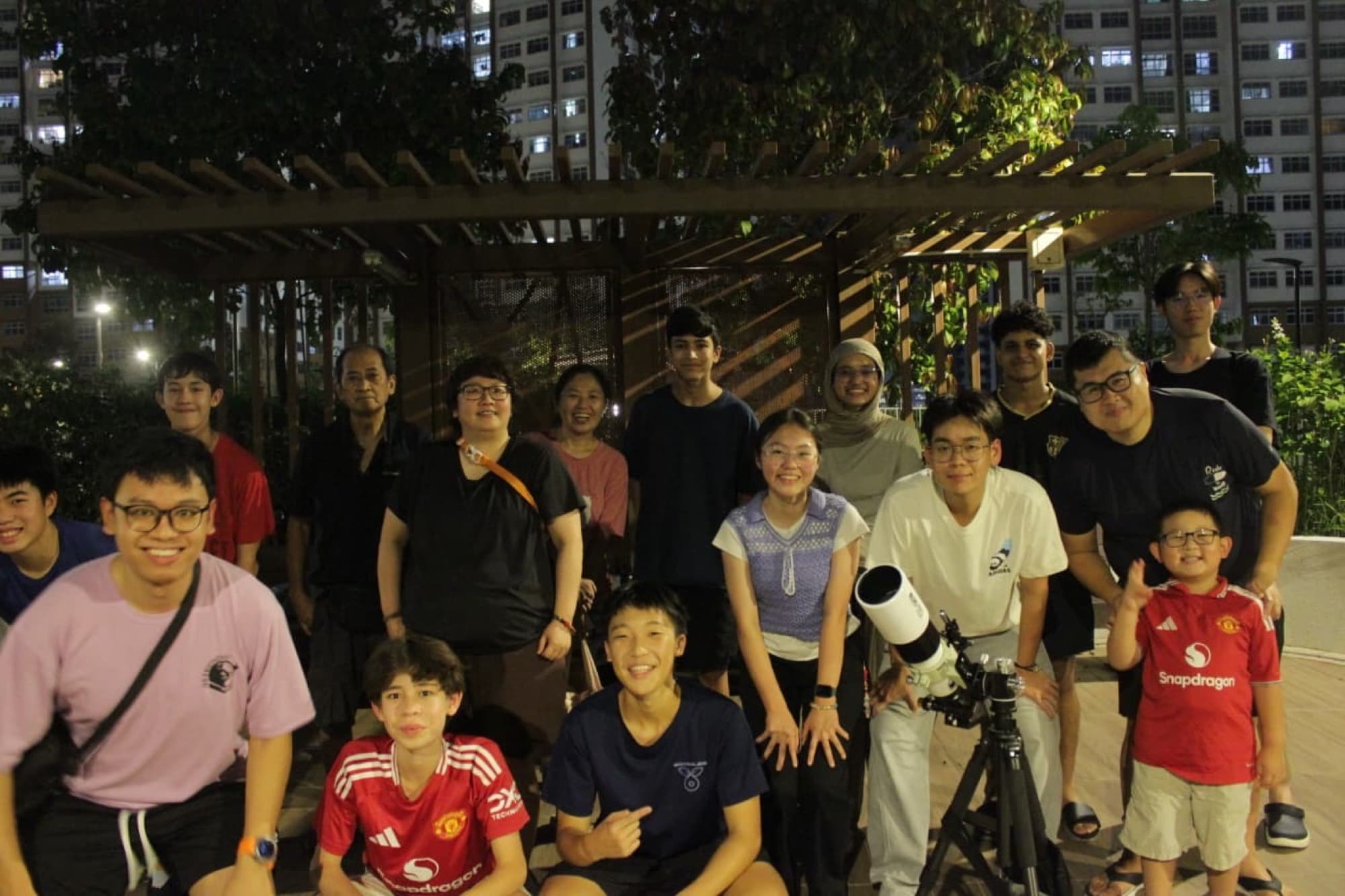 AstroYouth members with a telescope at a void deck session
