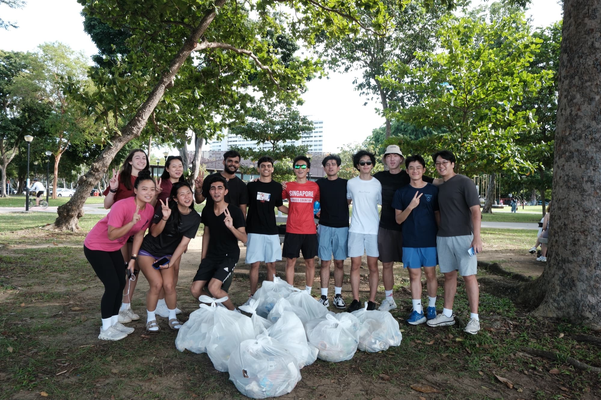 EcoMiles ploggers with collected waste bags under the trees