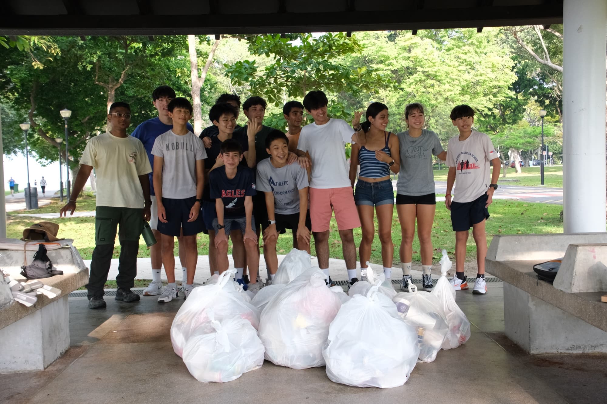EcoMiles ploggers with collected waste bags at a park pavilion