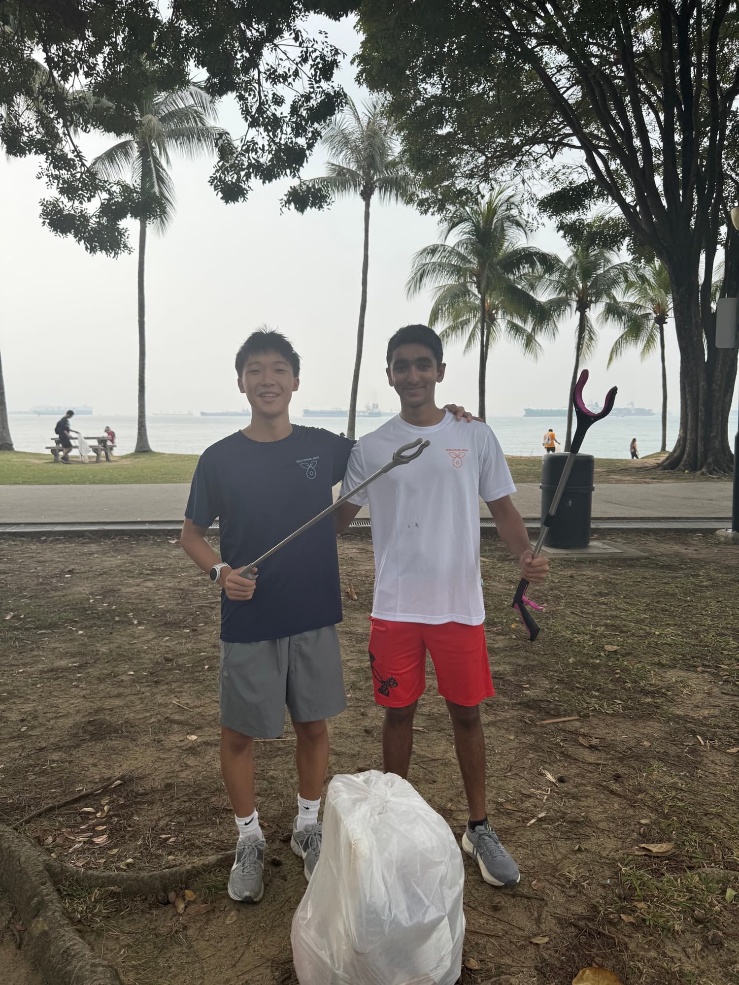 Sam and a friend posing with litter grabbers